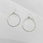Pair of handcrafted hammered sterling silver circle hoop earrings with textured finish and French ear wires, lightweight everyday hoops by Dawn Carlson Designs