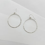 Pair of handcrafted hammered sterling silver circle hoop earrings with textured finish and French ear wires, lightweight everyday hoops by Dawn Carlson Designs