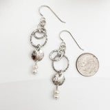 Sterling silver and pearl dangle earrings shown next to dime for scale, featuring textured hoops and luminous freshwater pearl drops, handmade by Dawn Carlson Designs