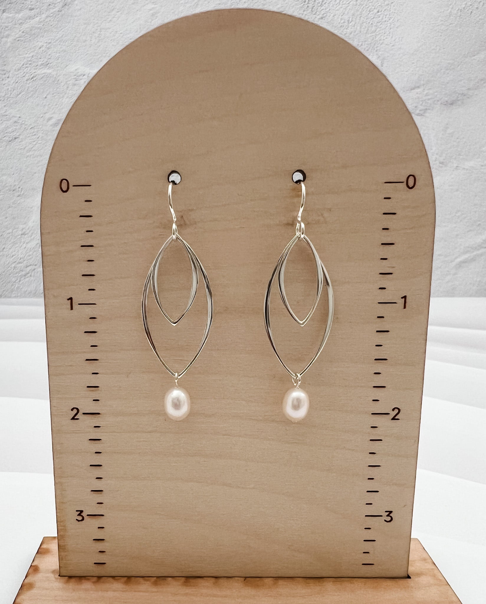 Lightweight sterling silver double marquis earrings with pearl drops measuring 2 inches in length on display stand