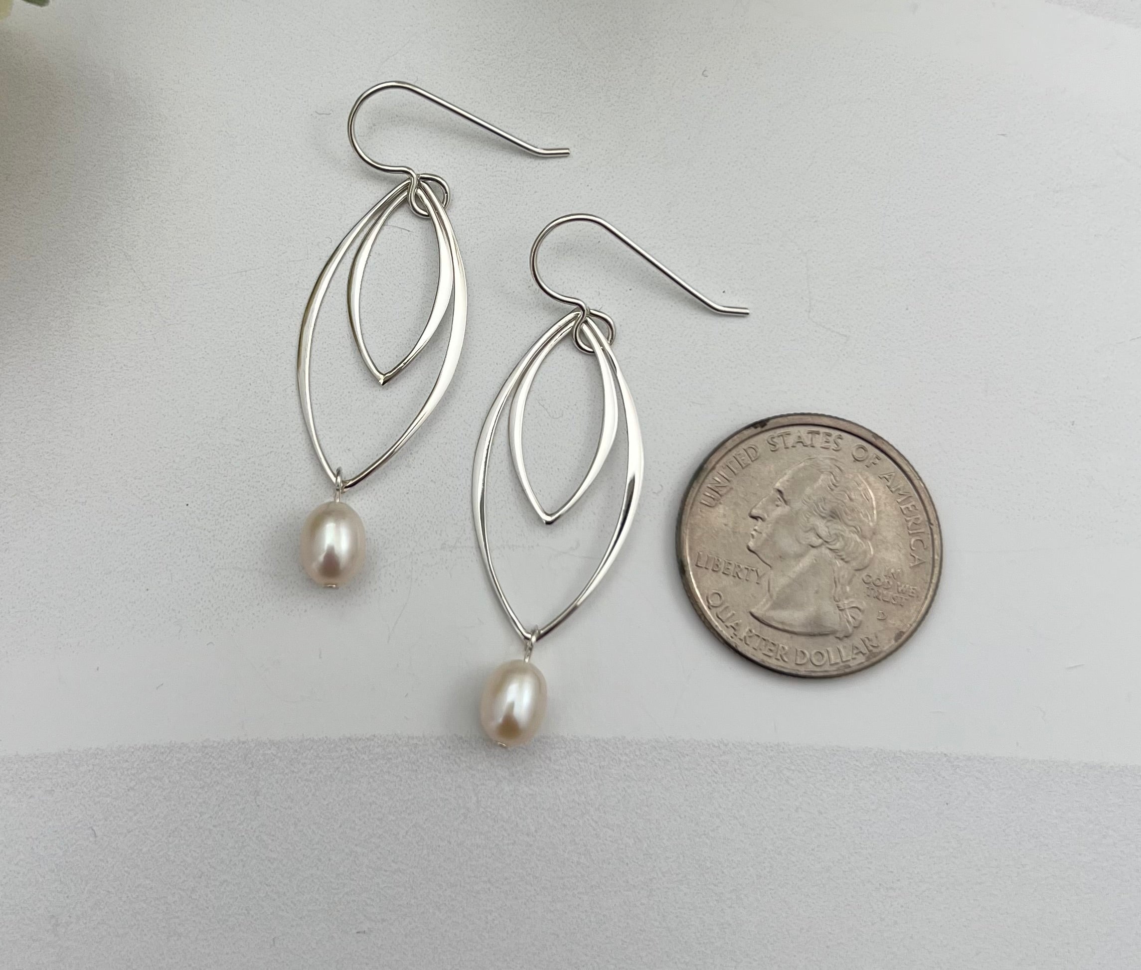 Handcrafted double marquis pearl drop earrings in sterling silver shown next to quarter for scale