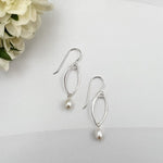 Marquis pearl drop earrings in sterling silver on white background with cream flower accent by Dawn Carlson Designs