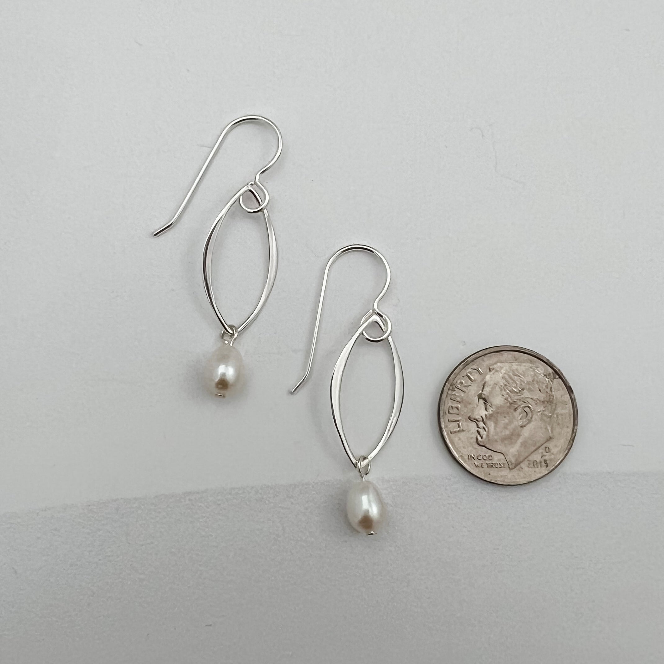 Sterling silver marquis pearl earrings next to dime showing 1.5 inch length and delicate size