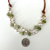 Double-strand freshwater pearl necklace on natural leather cord, accented with faceted green Czech glass beads and 14k gold filled jump rings, shown next to a dime for scale