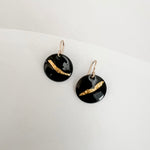 Close-up of black enamel drop earrings showing textured 24k gold foil sweep, handmade by Dawn Carlson Designs on a white background.