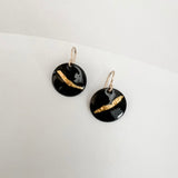 Close-up of black enamel drop earrings showing textured 24k gold foil sweep, handmade by Dawn Carlson Designs on a white background.