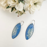 French blue enamel marquise earrings with cream flower petal pattern on sterling silver ear wires, styled with white fabric flowers