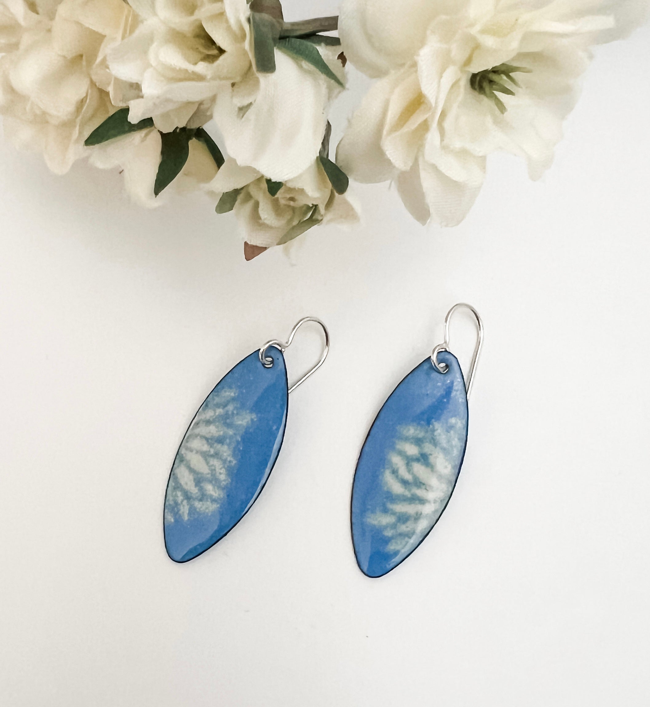 French blue enamel marquise earrings with cream flower petal pattern on sterling silver ear wires, styled with white fabric flowers