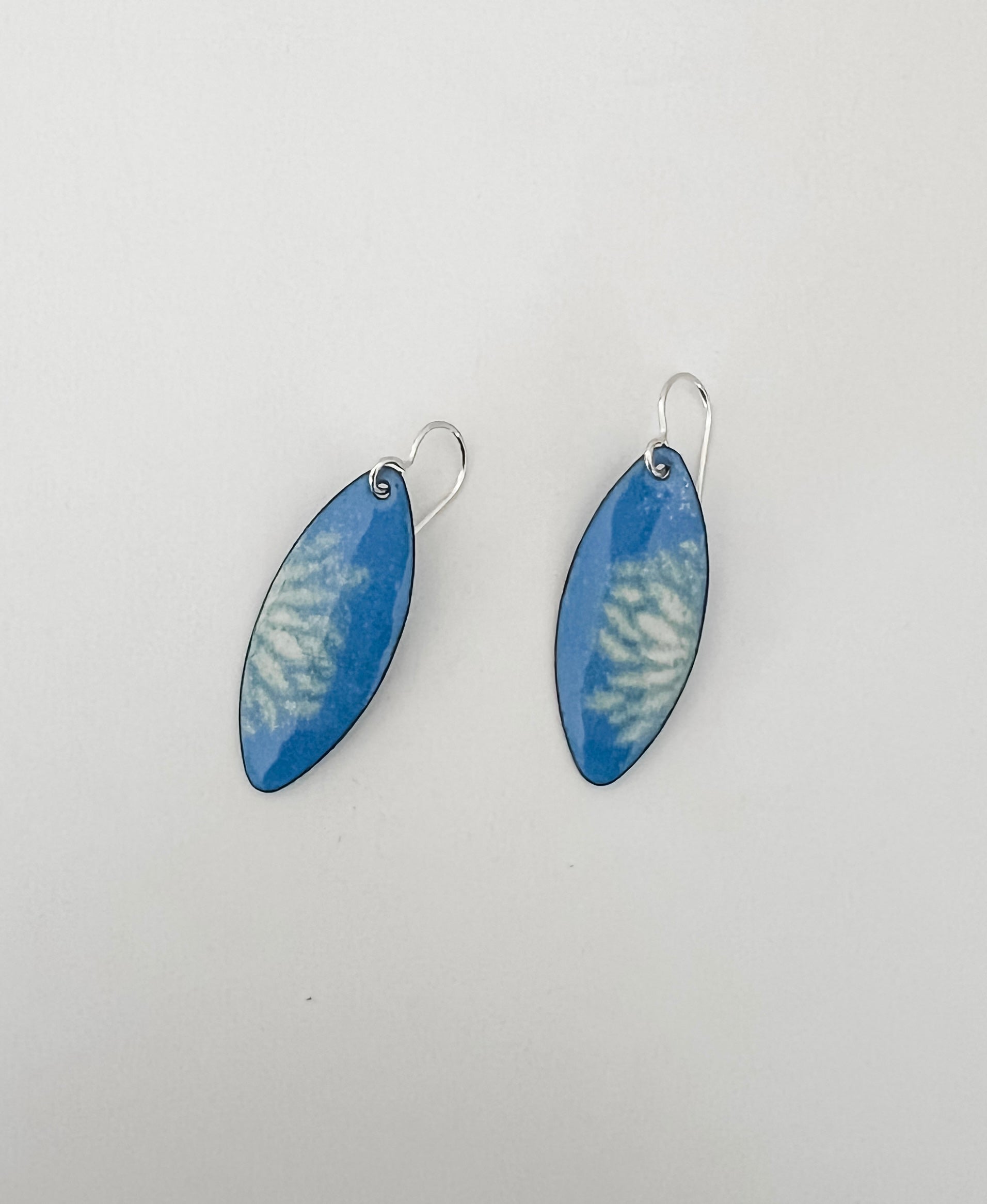 French blue enamel marquise earrings with cream flower petal pattern on sterling silver ear wires on white background 