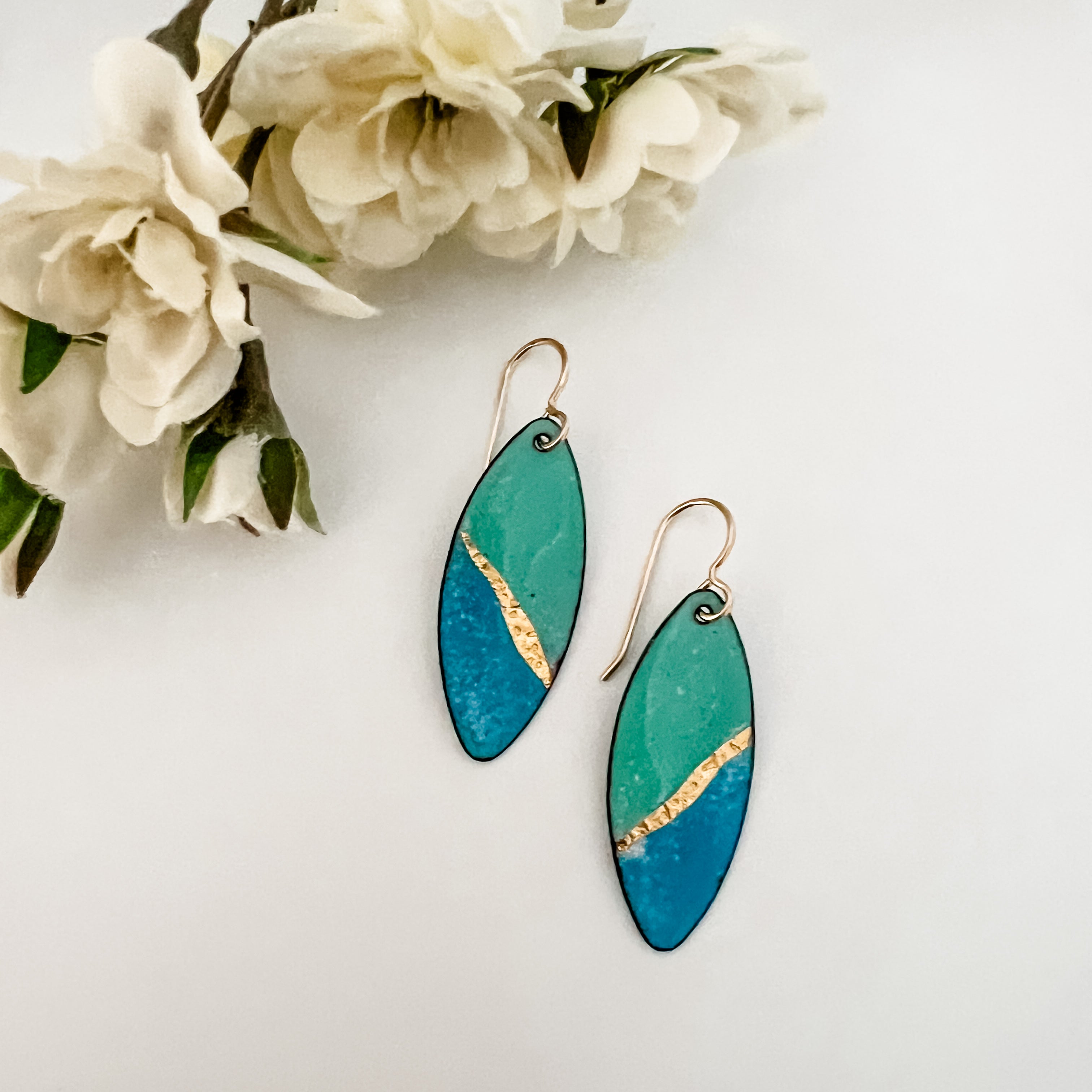  Seafoam green and blue enamel marquise drop earrings with 24k gold foil diagonal accent and 14k gold fill ear wires, styled with white fabric flowers