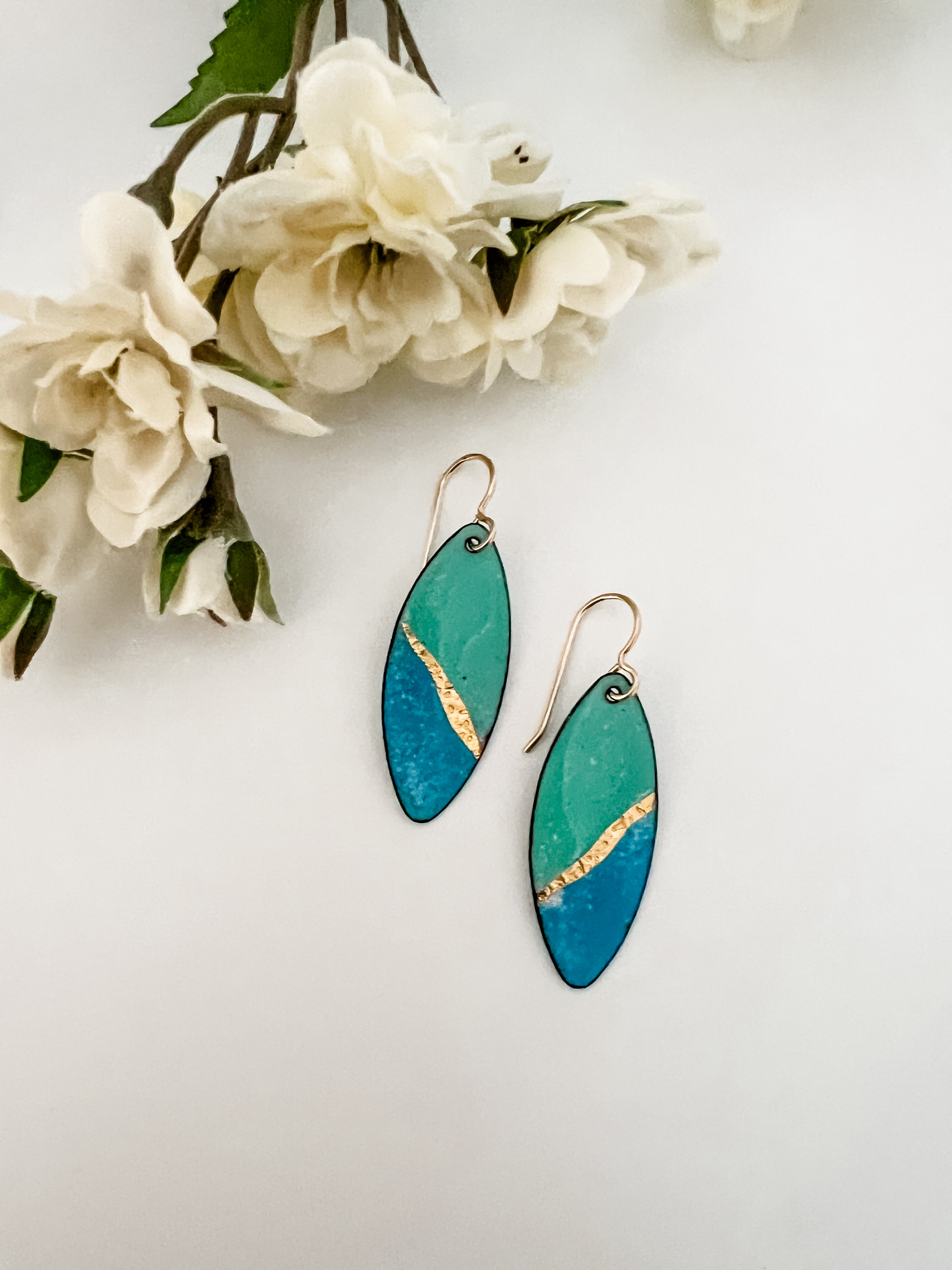  Seafoam green and blue enamel marquise drop earrings with 24k gold foil diagonal accent and 14k gold fill ear wires, styled with white fabric flowers