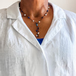 Apatite, sodalite and pearl lariat shown on model wearing a white linen blouse. Dawn Carlson Designs