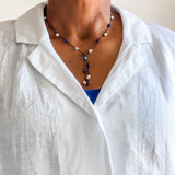 Apatite, sodalite and pearl lariat shown on model wearing a white linen blouse. Dawn Carlson Designs